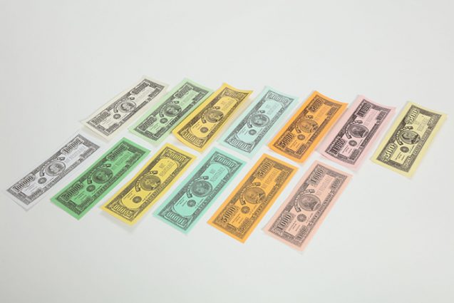 写真上列が『人生ゲーム』初代モデルのお札。印刷の濃度が違うなど多少の違いはあるものの、基本的なカラーリングは同じ。最も異なるのは、当時は500ドル紙幣が存在していたことだ。
