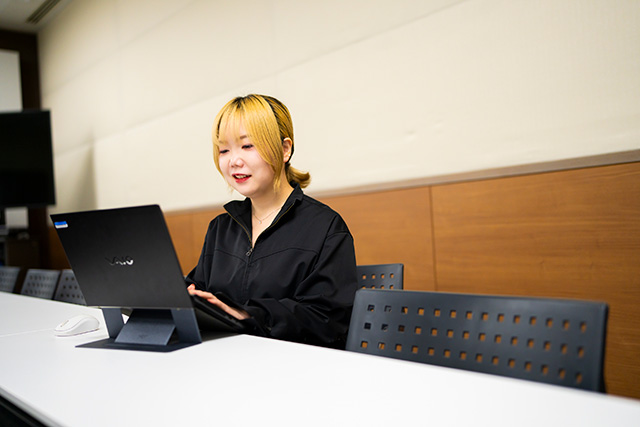 PCに向かって作業をするYUSA