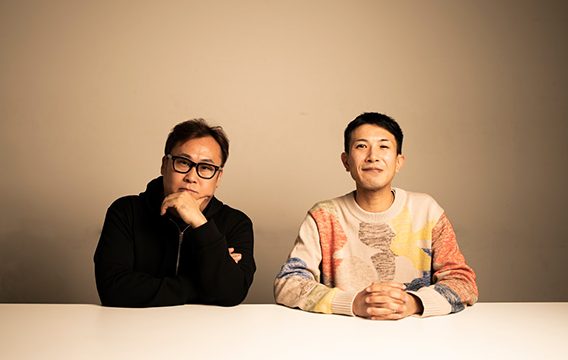 顎に手を当てる加藤と笑顔の藤井