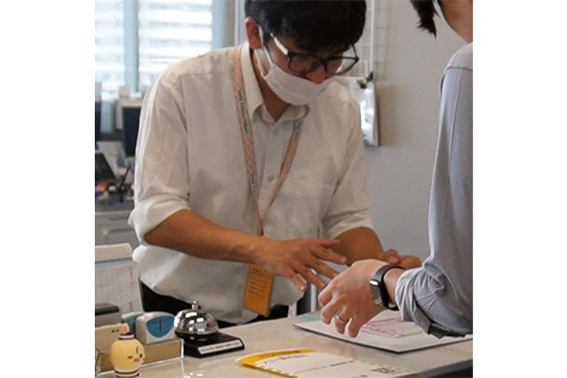 事務作業で受付を行なっている男性