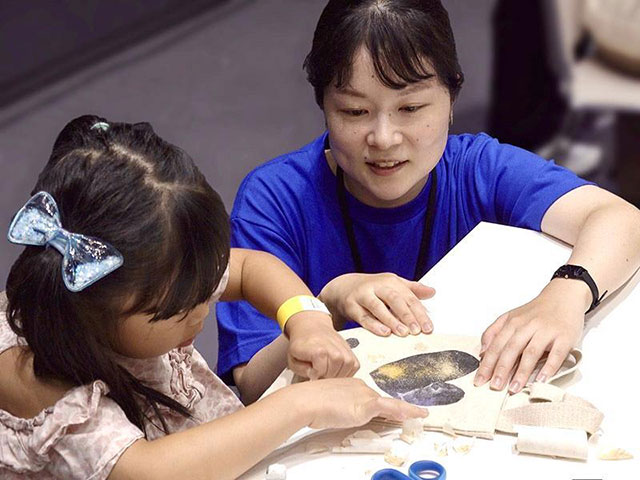 女性と子供が楽しそうに作業をしている