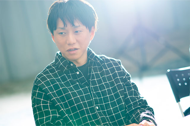 黒いチェックシャツを着た小山裕誠