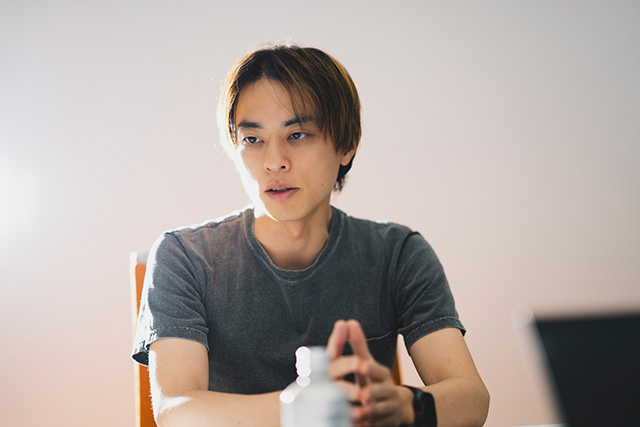 手のひらを合わせて話す片岡
