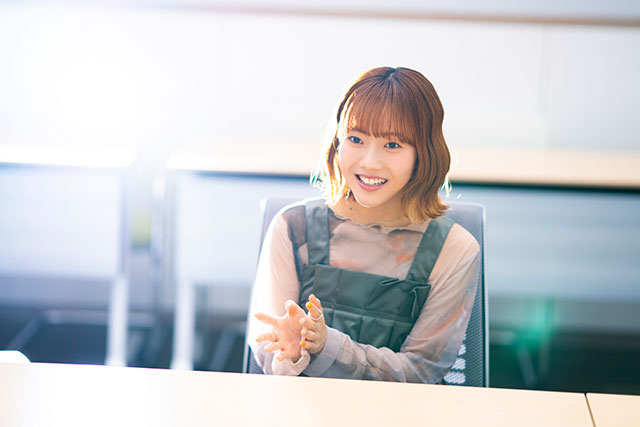 手振りを交えて話す早希