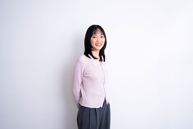 後ろ手を組み、笑顔をこちらに向けるYUKA